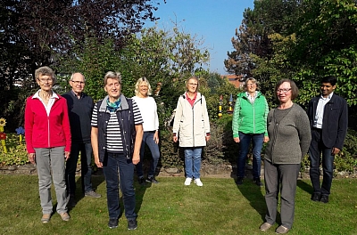 Mitarbeiter der Caritas Steinbeck stehen zu einem Gruppenbild zusammen im Garten